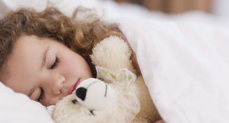 Girl sleeping with her teddy