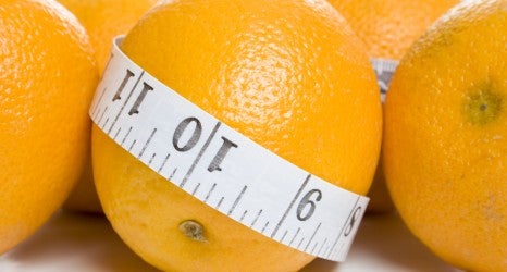 Orange wrapped in a measuring tape
