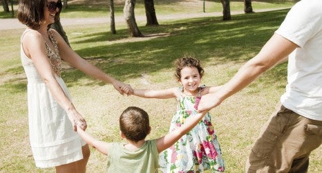 Young family embracing and enjoying with two young children